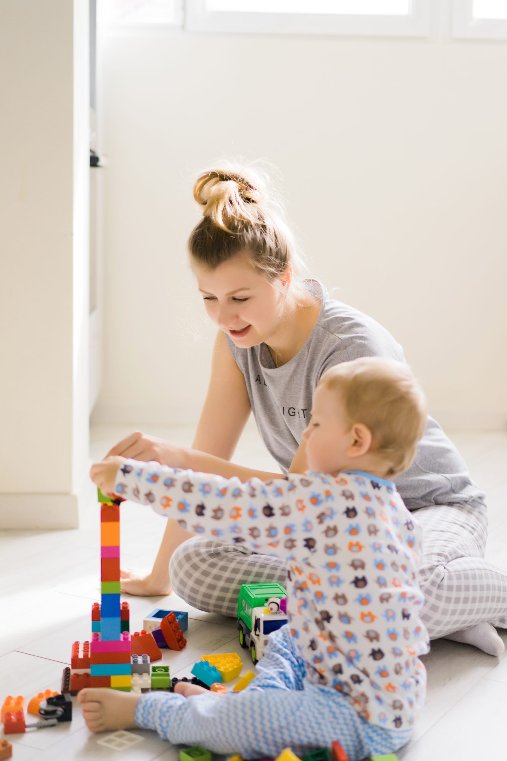 professionnelle petite enfance joue aux cubes avec enfant 