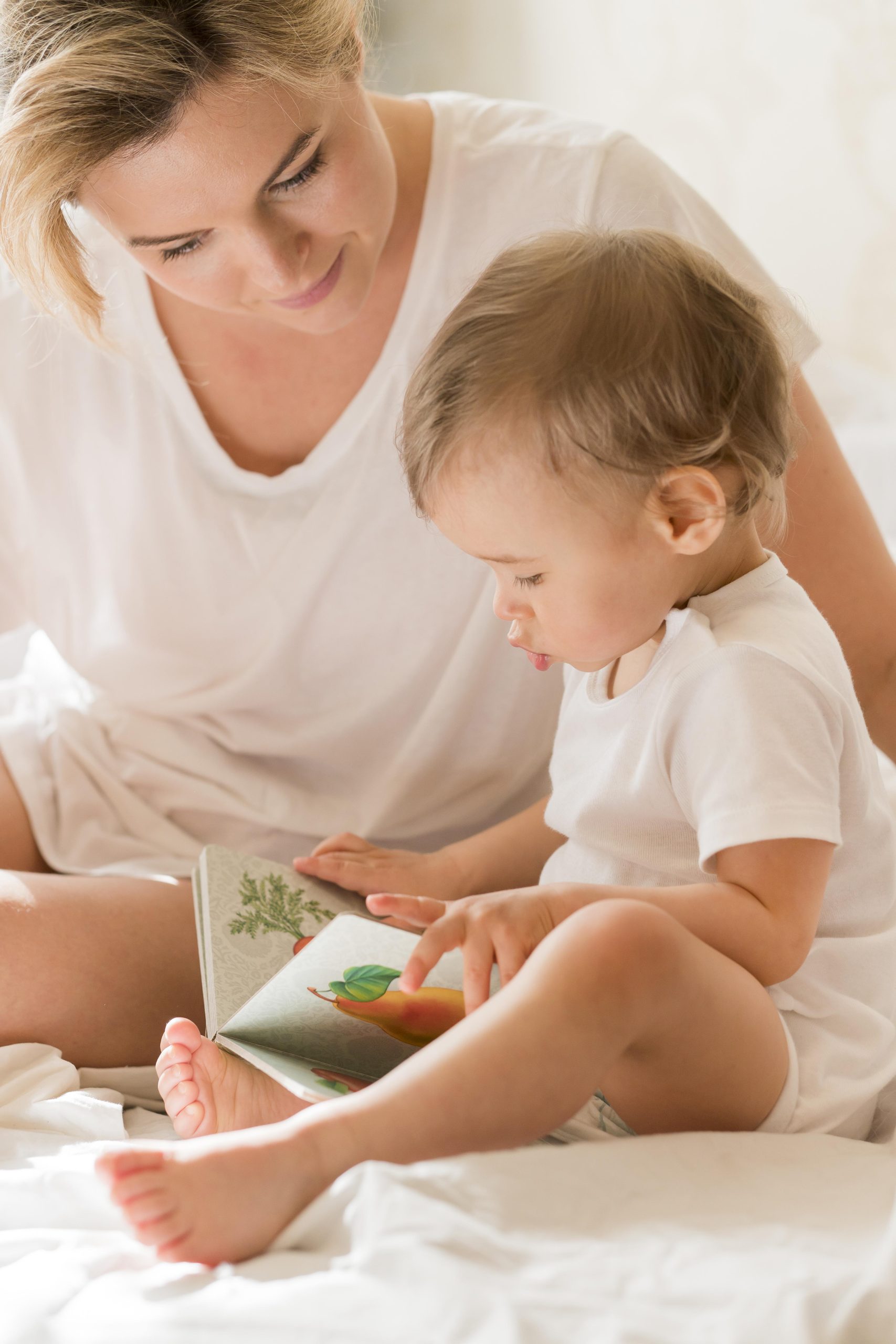 Professionnelle petite enfance accompagne un enfant qui lit